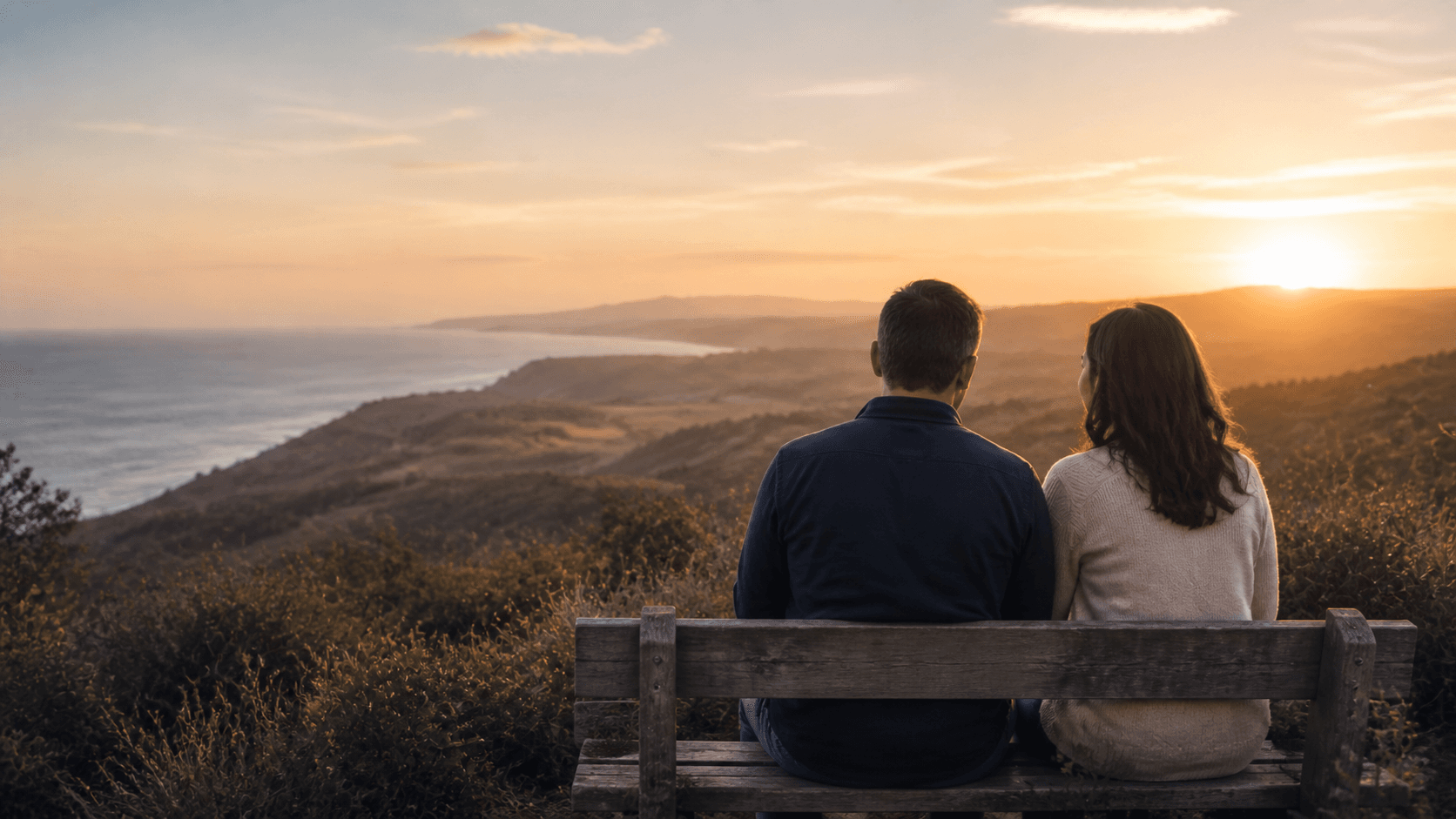 A couple looking together toward a peaceful coastal horizon